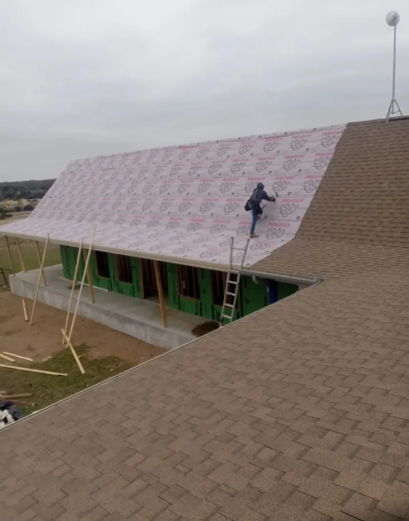 Worker preparing underlayment for a metal roof installation in Shillington